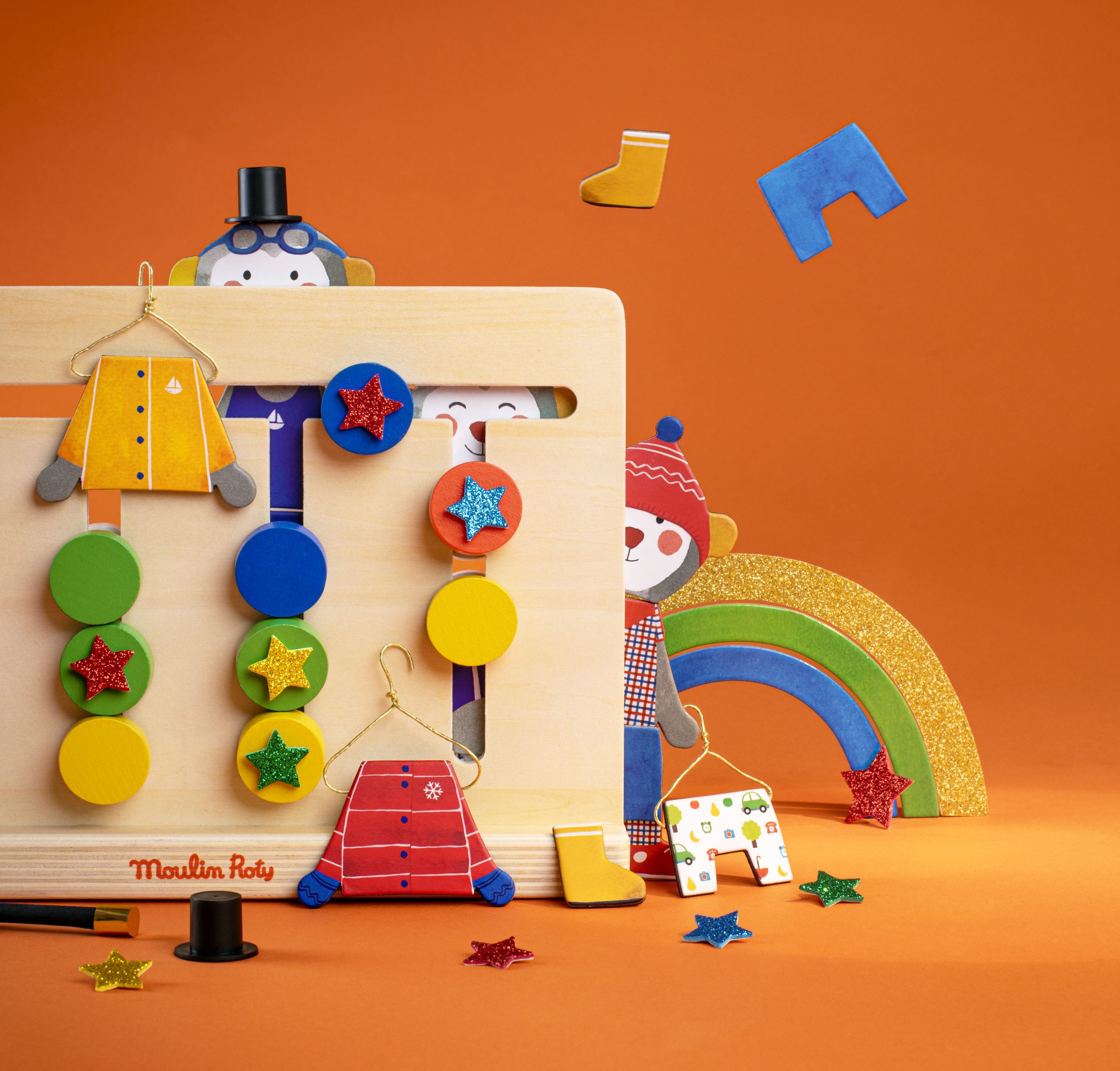 popipop toys hiding behind sensory board and rainbow in background