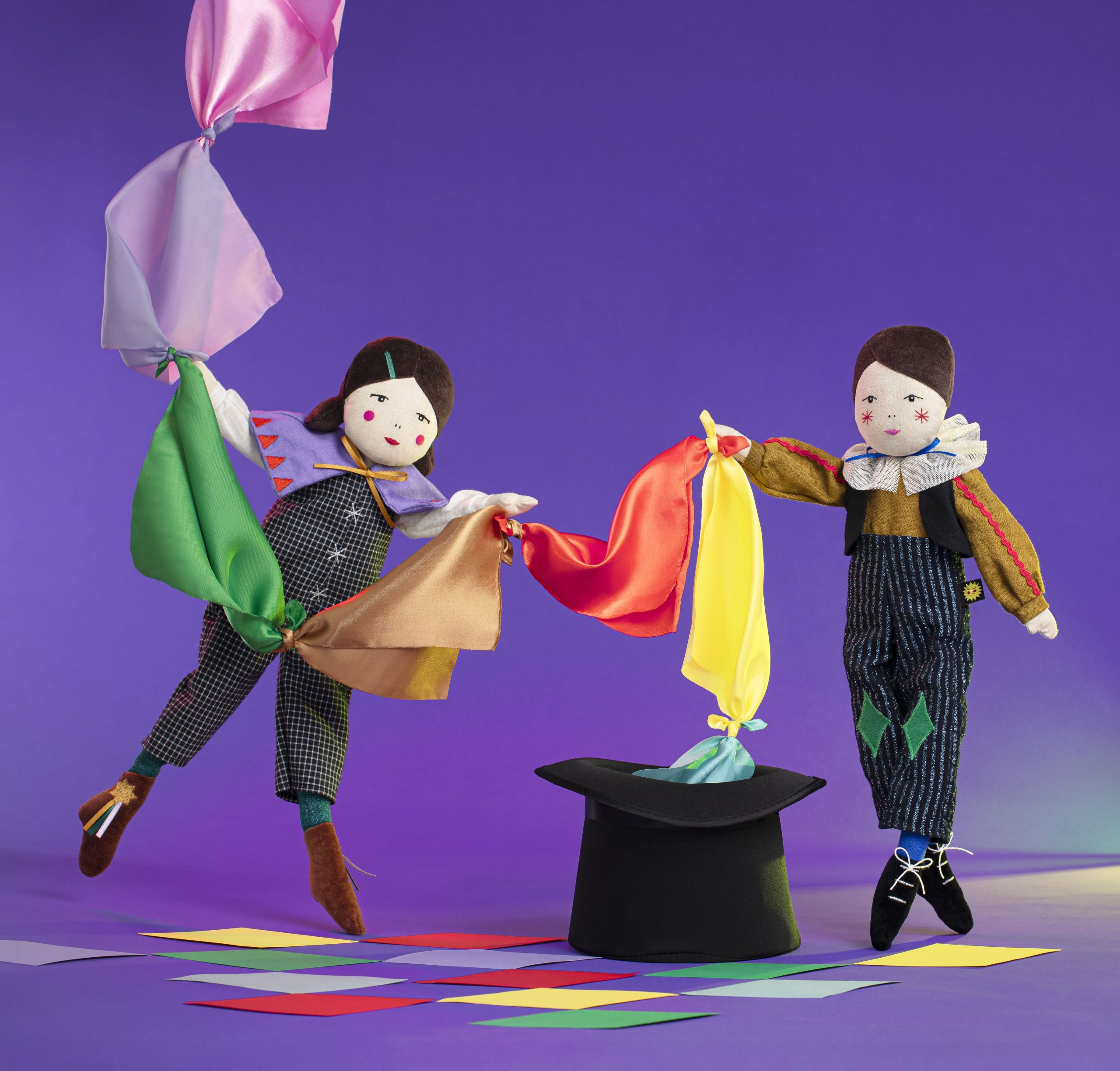 dolls making string of juggling flags out of a top hat