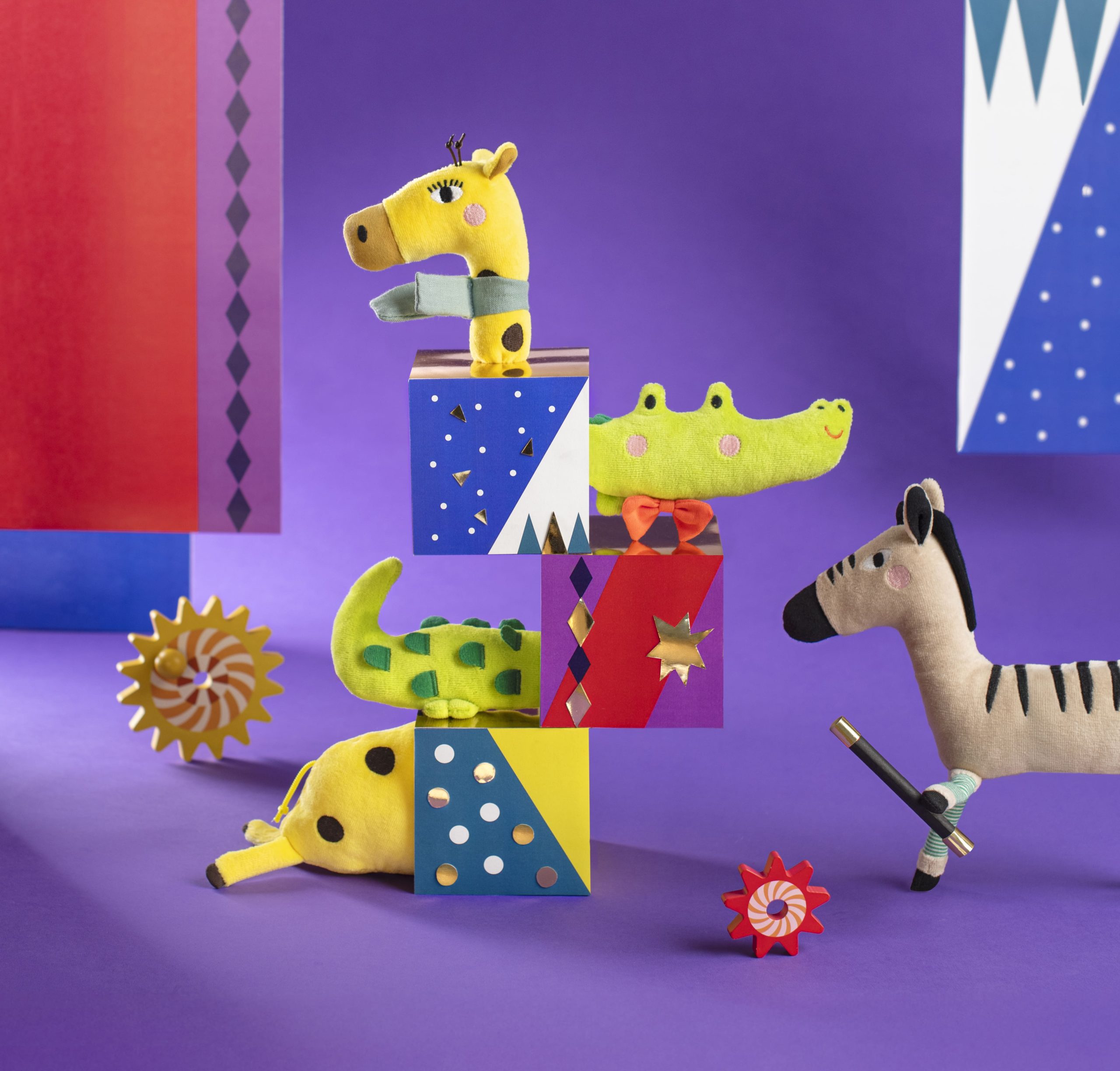 stack of blocks, animals and soft toys on purple background