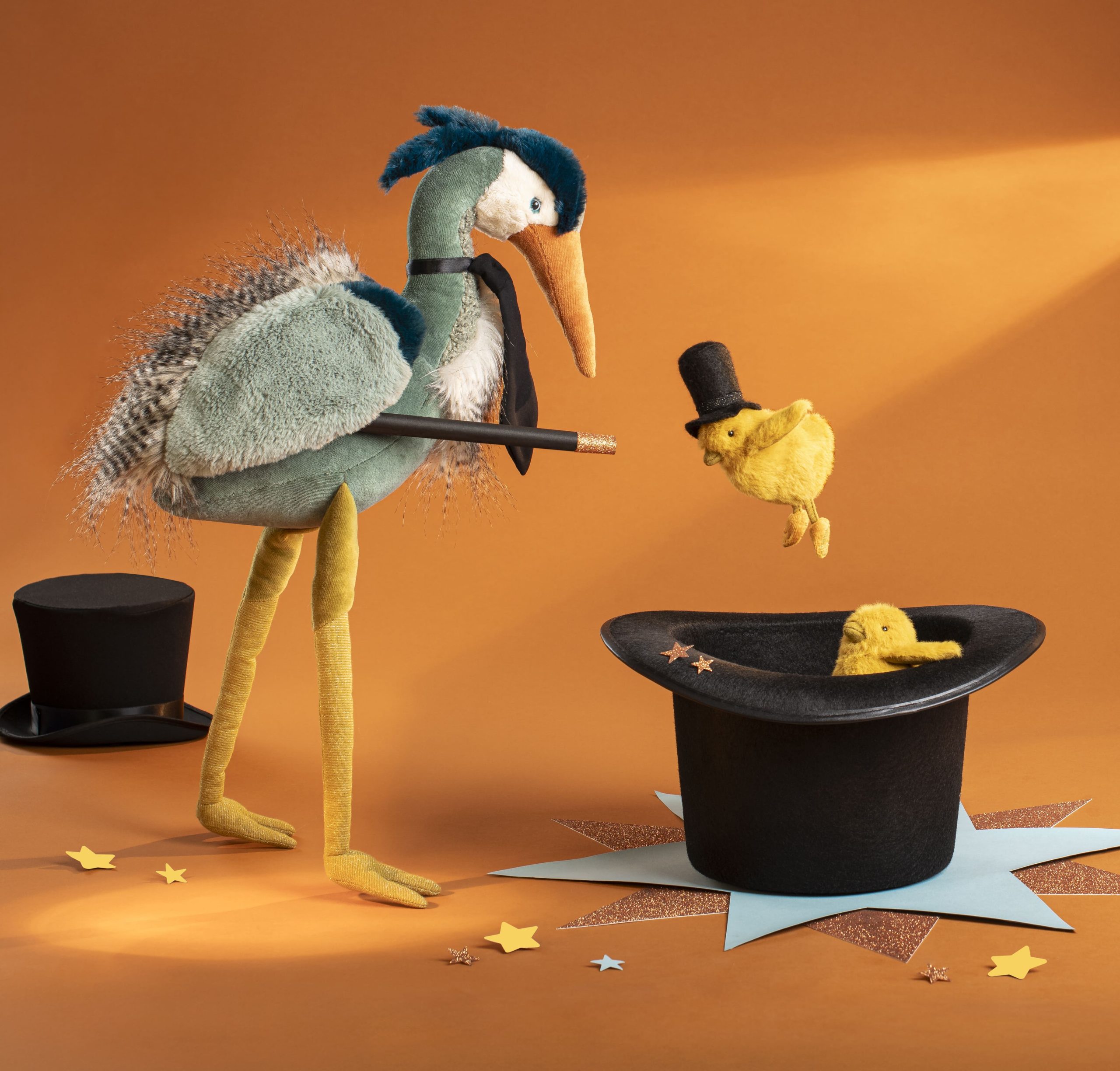 heron toy doing magic trick with yellow baby chickens in a top hat